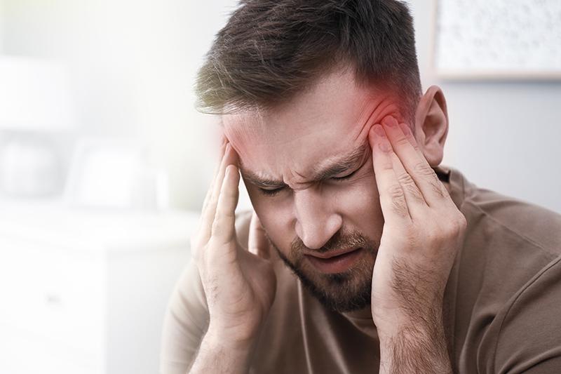 Man waking up with a migraine headache